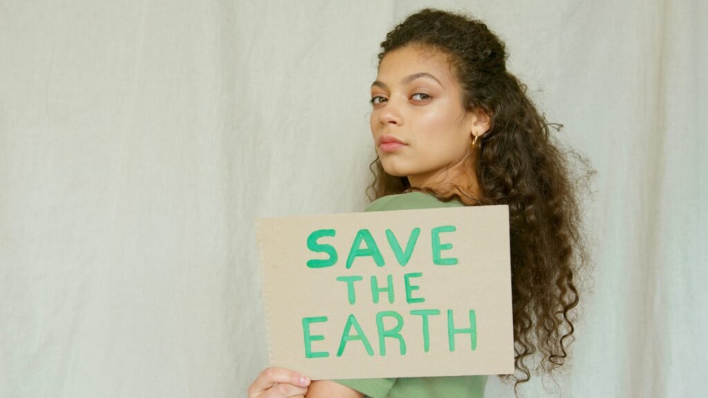 Portrait of a woman holding a 'Save the Earth' sign, promoting environmental awareness.
moda sostenible